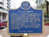 blue plaque with gold Chinese letters and crest of deer and a bearat the top