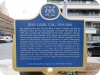 blue plaque with gold writing and crest of deers and a bearat the top