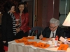 Chinese Calligraphist painting Chinese letters on bright orange paper