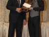 two men standing together holding plaques