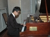 young man playing grand piano