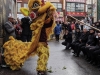 Chinese Lion dancer in large yellow and red mask.