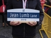 hands holding the Jean Lumb lane sign.