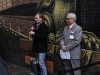 man speaking in laneway to crowd of attendees