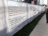 Large sign attached to chain link fence describing Jean Lumb Groundbreaking Event.