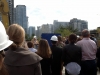 Crowd of people with several construction workers in hard hats.