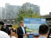 Toronto Mayor speaking behind podium to audience with building plans behind him.