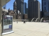 big open square surrounded by skyscrapers and people walking by