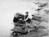 Young Chinese man standing in a flooded area with debris