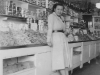 Jean leaning against display in her fruit and vagetable shop