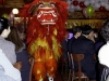 big red and gold chinese lion dancing down aisle between guests seated at tables