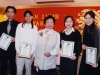 four students holding their awards, standing next to Jean Lumb