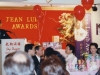 banquet hall with guests seated at tables, red walls with Jean Lumb banner and balloons