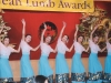 children dancing with bright blue skirts formed in a line