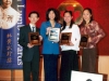 people standing together for photo holding awards