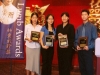four people holding award plaques