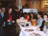 long reception table with four volunteers greeting crowd of guests