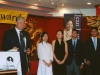 man speaking at mircrophone with four award winners in line next to him