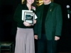 award winner holding plaque standing next to presenter