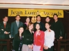 people grouped together onstage for a picture under Jean Lumb banner