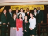 people grouped together onstage for a picture under Jean Lumb banner