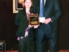 award winner holding plaque standing next to presenter