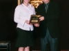 award winner holding plaque standing next to presenter