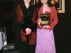 award winner holding plaque standing next to presenter