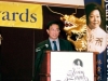 man speaking onstage behind podium
