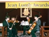 four musicians performing with a cello and three violins