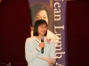 women holding microphone and sheet of paper