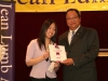 man holding award plaque, handing it over to winner