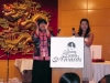 emcees standing behind podium clapping their hands