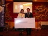 two people on stage holding a giant sized cheque from