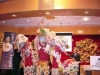 dancers in chinese lion costume, with large face masks, red fabric, white and gold fringes