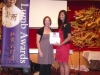 presenter handing award to winner next to Jean Lumb banner