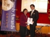 presenter handing award to winner next to Jean Lumb banner