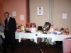long table with items, such as tea pot, koala bear stuffed animal, gift bags