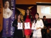 three women standing with their awards next to Jean Lumb banner