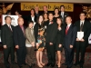 large group of award winners and presenters standing on stage under Jean Lumb foundation banner
