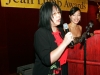 two women standing at podium holding  microphone