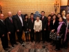 group of fifteen people stand for photo infront of heritage plaque
