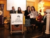several people standing around podium and women is being given plaque as an award