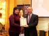 man shaking women's hand and giving her an award