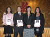 three award winners posing with their plaques