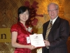 young  chinese female award winner being presented with plaque