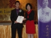 young chinese man award winner presented with plaque.
