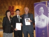 two award winners standing with plaques next to Jean Lump banner and foundation president