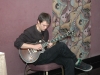 Connor Chan seated playing guitar