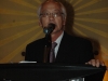 Dr. Ken Lumb greets guests speaking behind podium